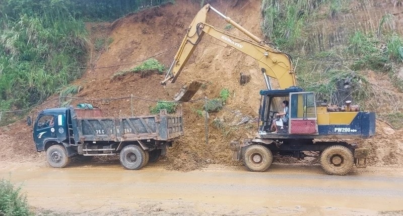 Đơn vị quản lý đường bộ Thanh Hóa huy động máy móc khắc phục sạt lở trên Quốc lộ 15C. (ảnh PV)