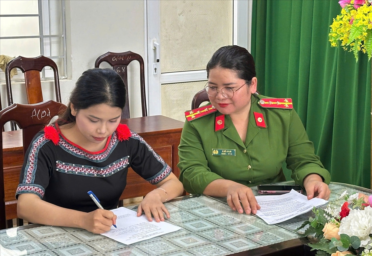 Cán bộ Công an xã Krông Búk hướng dẫn thanh niên làm đơn tình nguyện nhập ngũ (ảnh: NT)