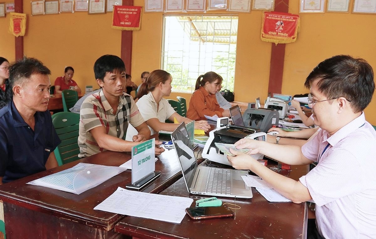 Cán bộ Phòng Giao dịch Ngân hàng chính sách xã hội Hàm Yên giải ngân vốn cho người dân xã Hùng Đức (ảnh Hoàng Ngọc)