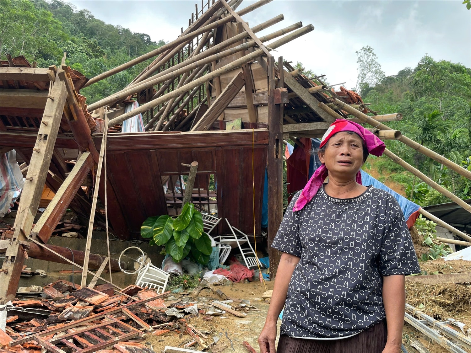 Bà Lang Thị Luyến (55 tuổi), bật khóc trước căn nhà bị lũ phá tan hoang.(ảnh Quỳnh Trâm)