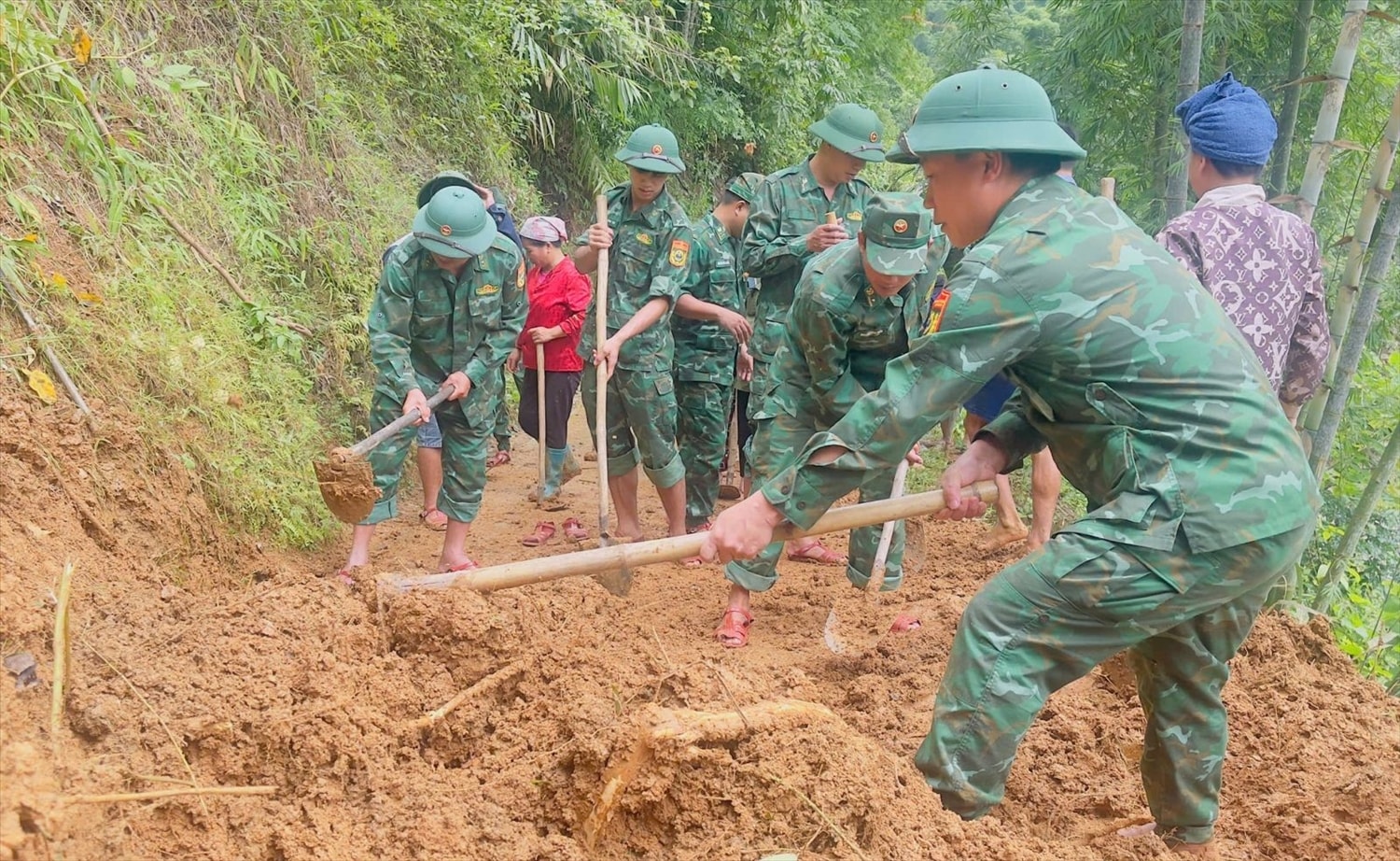 Bộ đội Biên phòng Hiền Kiệt giúp dân khắc phục các tuyến đường bị sạt lở. Ảnh: CTV