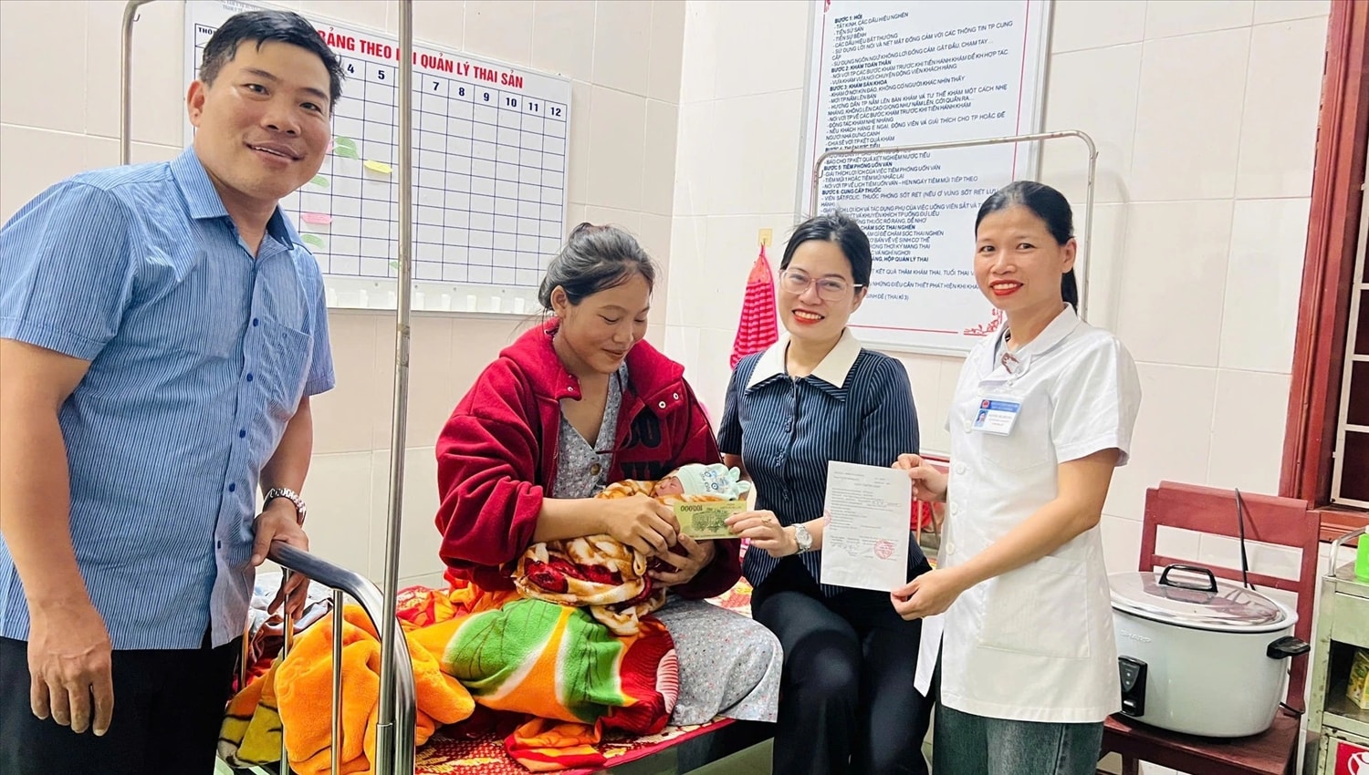 Bà Nguyễn Thị Hoài Ly (thứ 2 trái sang) trao món quà cho cháu Hồ Quốc Khánh - Ảnh: CSCC