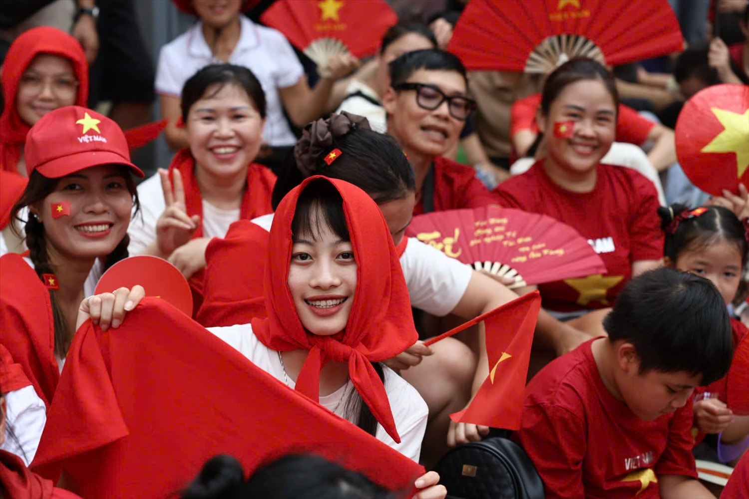 Những ánh mắt rạng ngời, những cánh tay vẫy cờ đỏ, tất cả hòa thành một nhịp điệu chung: bản hoà ca của lòng dân. Ảnh Đỗ Cường