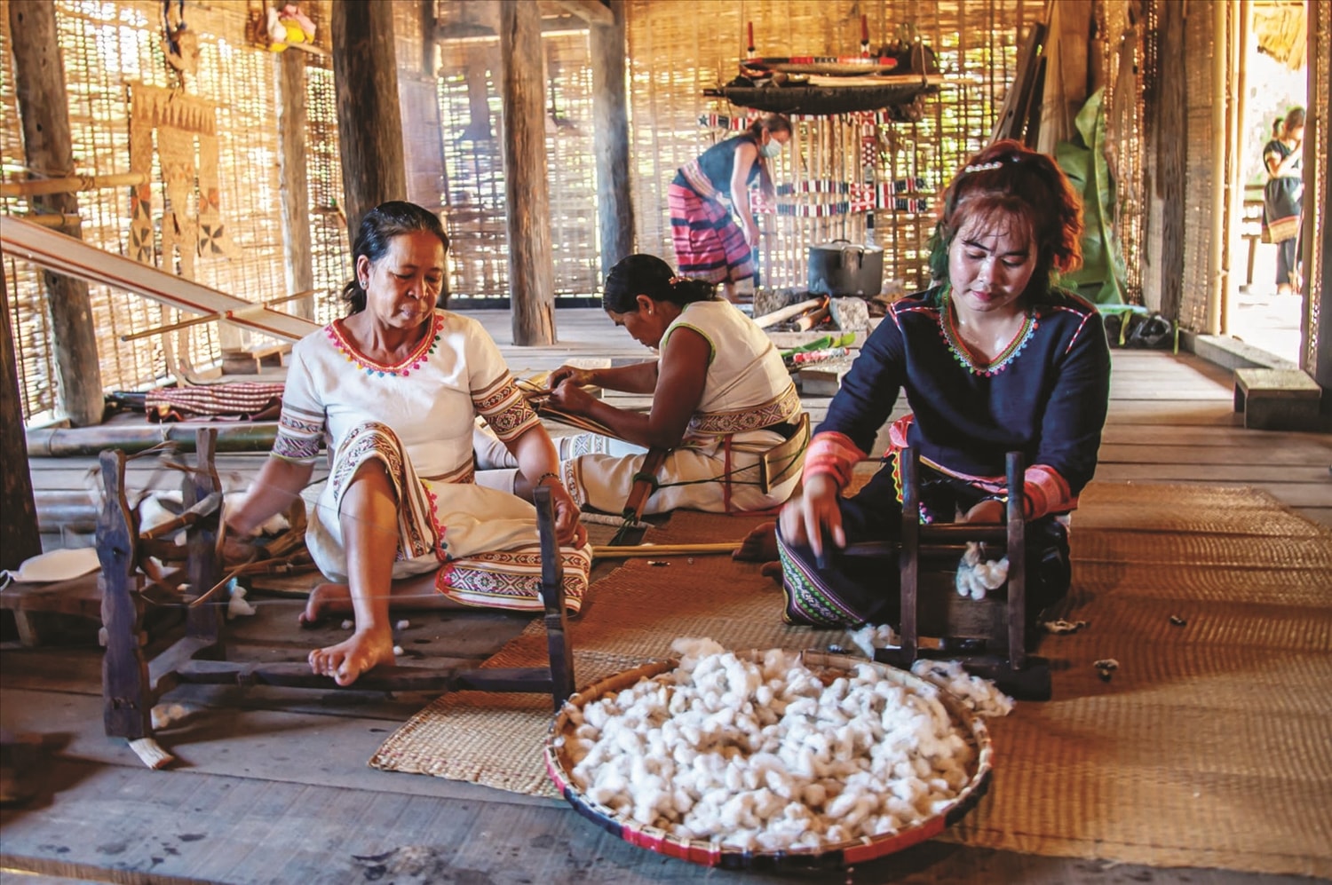 Phụ nữ dân tộc Rơ Măm, xã Mô Rai, tỉnh Quảng Ngãi, cán bông bằng dụng cụ truyền thống,  làm cho bông mềm và dễ dàng cho quá trình kéo sợi