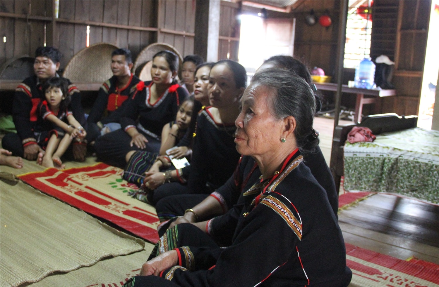 Bà H Y Ênuôl (ngồi đầu) cùng con cháu, bà con theo dõi lễ diễu binh (ảnh: Lê Hường)