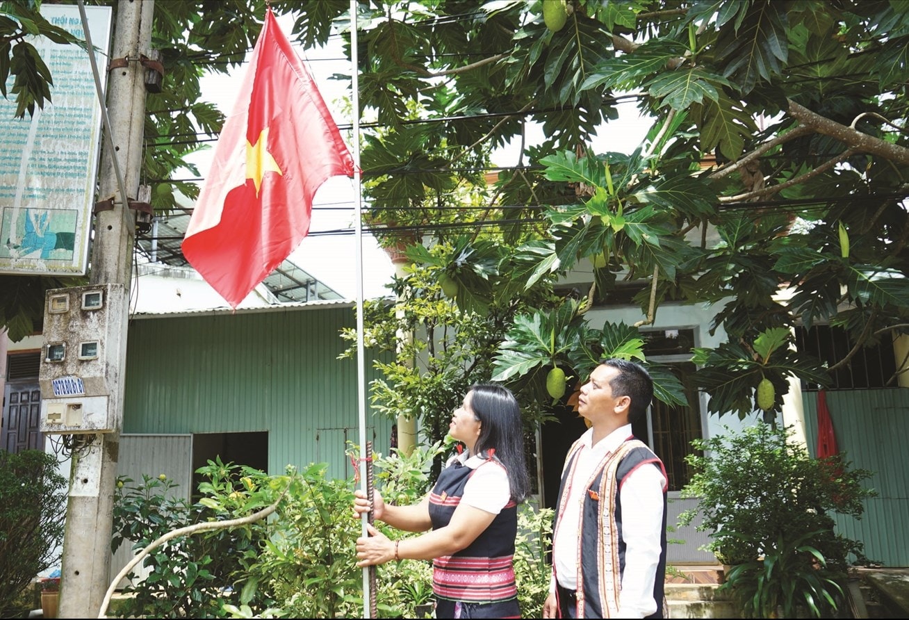 Chị Rơ châm Alui (làng Mông Yố 2) cùng dân làng treo cờ đỏ sao vàng  trước nhà chào đón ngày Lễ lớn của đất nước