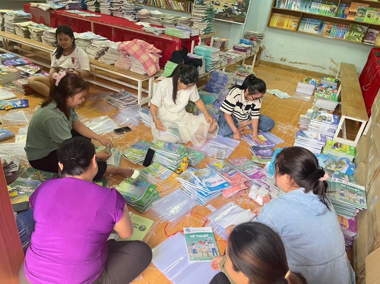 Giáo viên ở điểm trường xã A Vương soạn sách giáo khoa chuẩn bị cho năm học mới. (Ảnh Trường Quân).