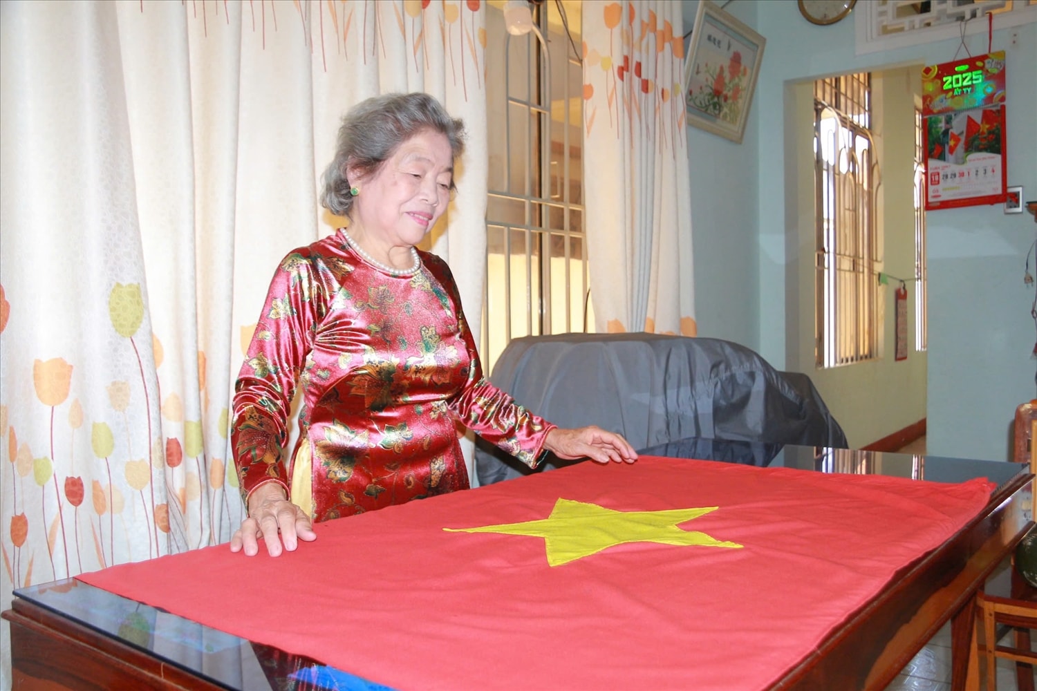 Bà Nguyễn Thị Ngọc Lan rất tự hào khi kể về nhiệm vụ thiêng liêng may cờ Tổ quốc và hành trình giữ sắc cờ trong bom đạn (Ảnh: Lê Hường)