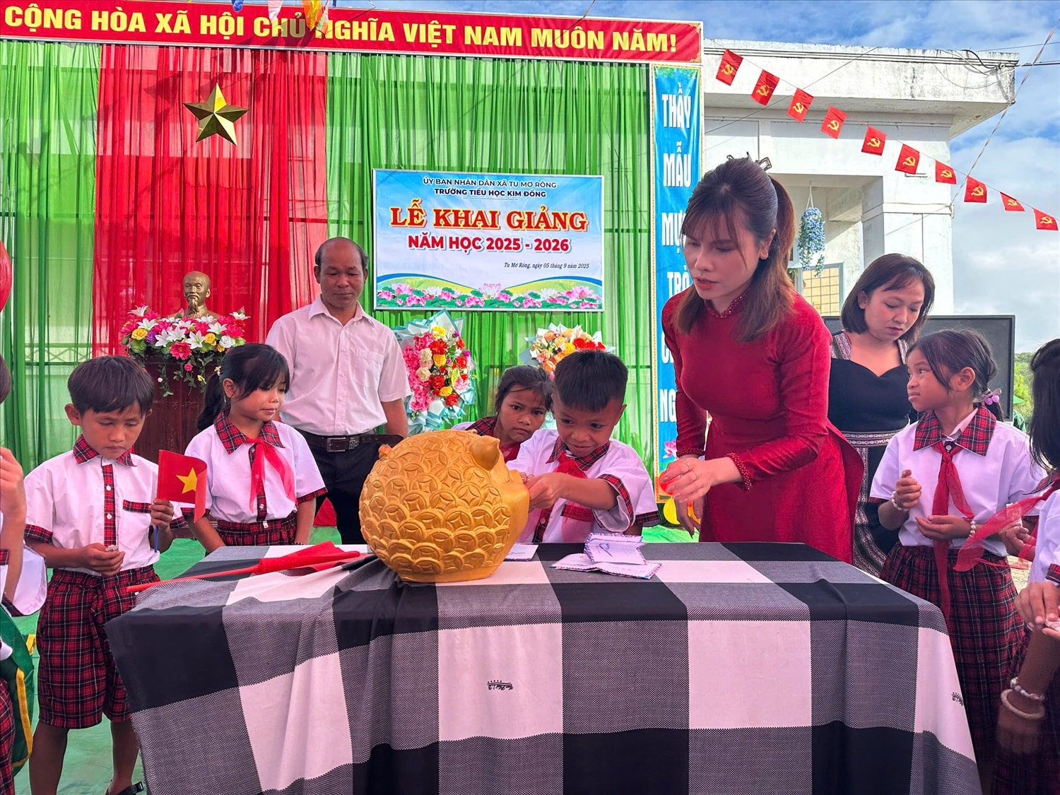 Học sinh Trường Tiểu học Kim Đồng, xã Tu Mơ Rông, tỉnh Quảng Ngãi tham gia bỏ heo đất để gây quỹ nuôi học sinh nghèo. (Ảnh: Ngọc Chí)