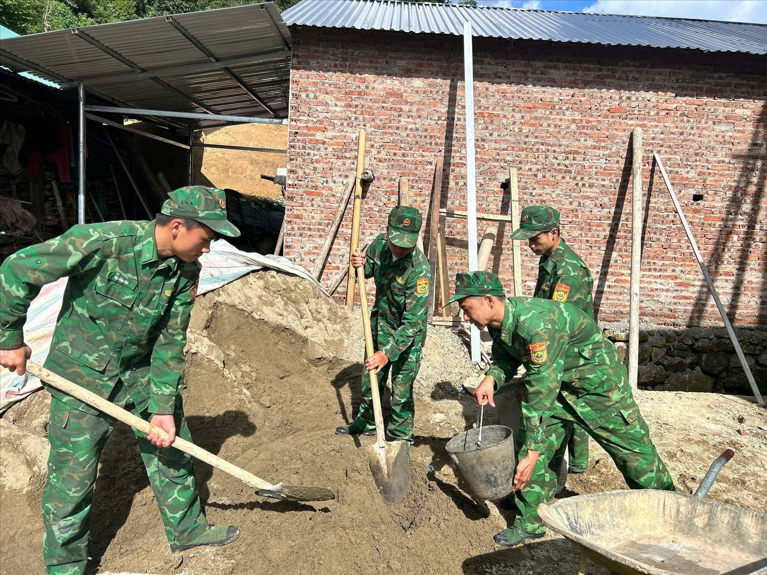 Cán bộ, chiến sĩ Đồn Biên phòng Vàng Ma Chải hỗ trợ gia đình bà Phùng Tả Mẩy xây dựng nhà