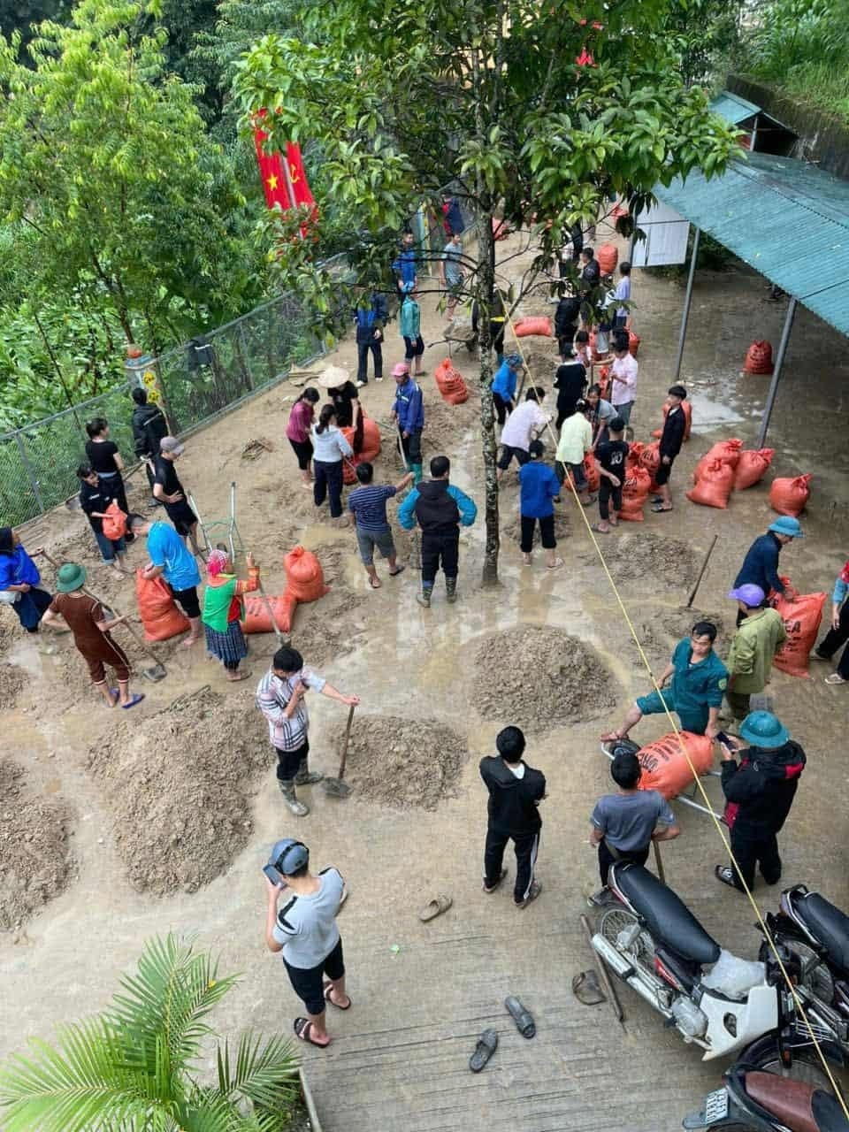 Các lực lượng phối hợp thu dọn phần bùn đất tại những khu vực an toàn