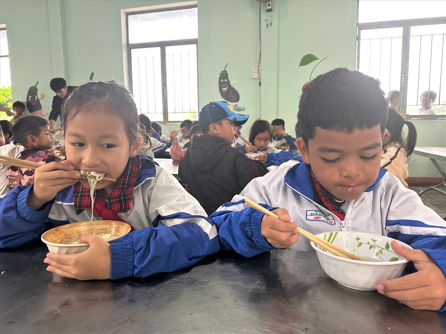 Các em học sinh rất vui khi được ăn bữa sáng miễn phí tại trường do chính các thầy, cô nấu. (Ảnh: Ngọc Chí)