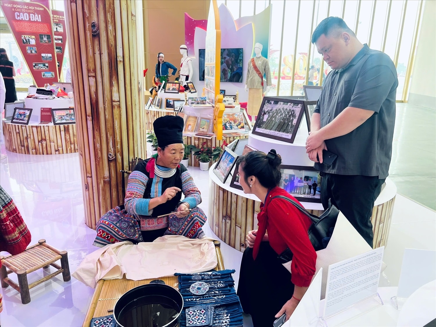 Du khách trải nghiệm nghệ thuật vẽ sáp ong của đồng bào dân tộc Mông tại Khu trưng bày của Bộ Dân tộc và Tôn giáo
