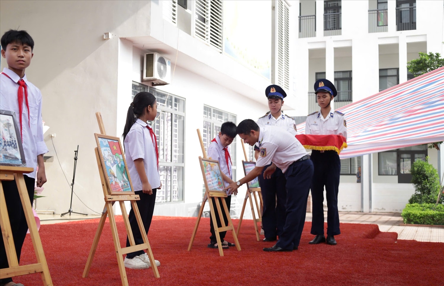 Trung tá Bùi Đức Thịnh - Chủ nhiệm Chính trị trao quà cho các học sinh đạt giải trong cuộc thi vẽ tranh về biển, đảo. (Ảnh: Văn Minh)