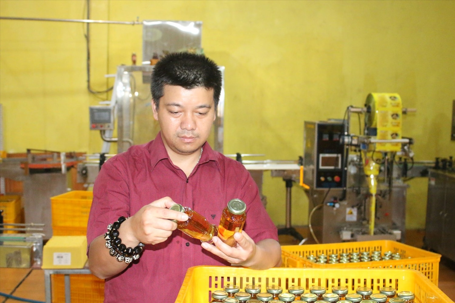 Anh Bền Chí Thịnh kiểm tra sản phẩm nước đóng chai Hồng đẳng sâm Kora trước khi đóng gói. (Ảnh: Ngọc Chí) Anh Bền Chí Thịnh kiểm tra sản phẩm nước đóng chai Hồng đẳng sâm Kora trước khi đóng gói. (Ảnh: Ngọc Chí)