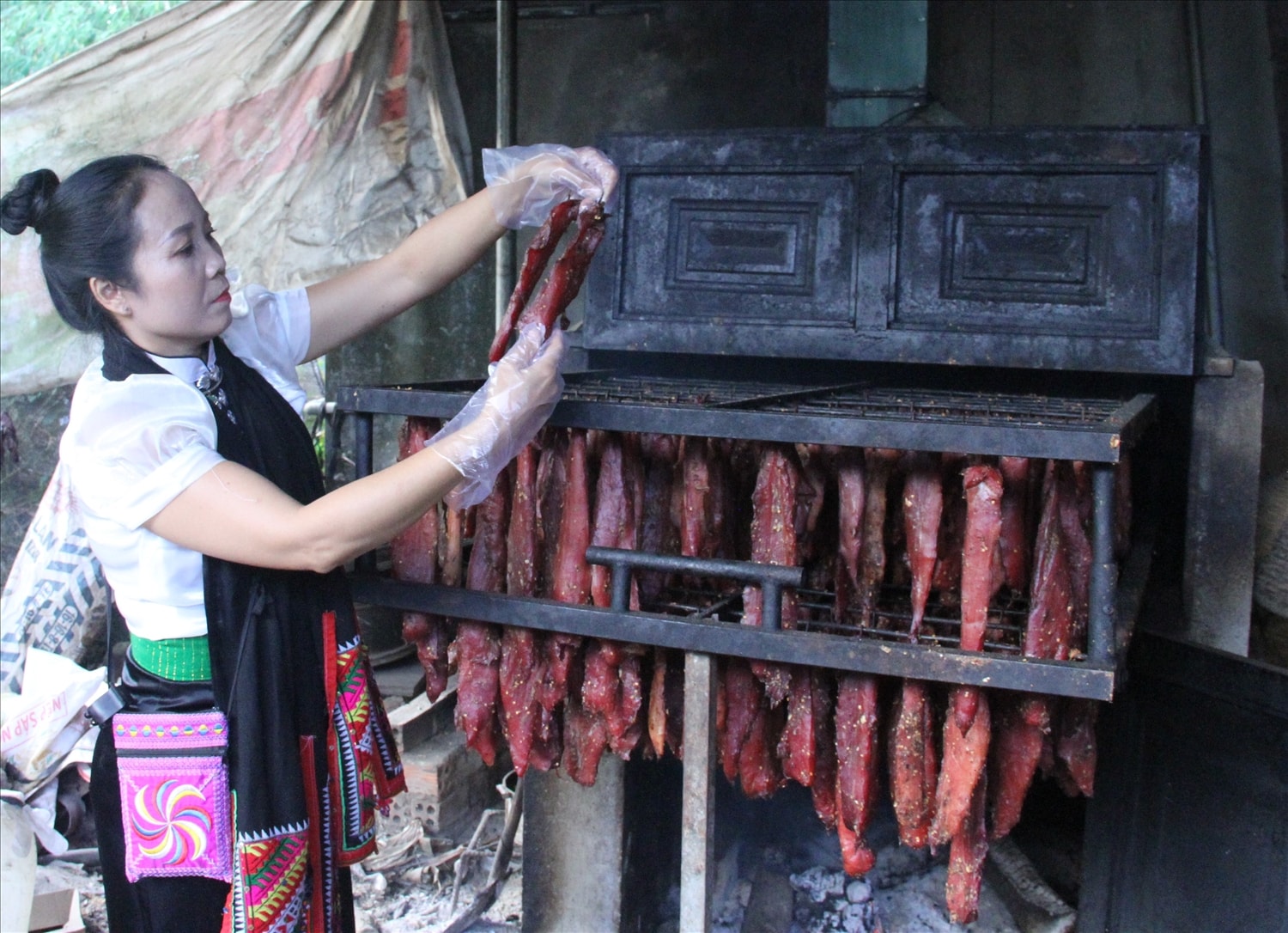 Chị Hạnh kiểm tra thịt trâu gác bếp (Ảnh: Lê Hường)