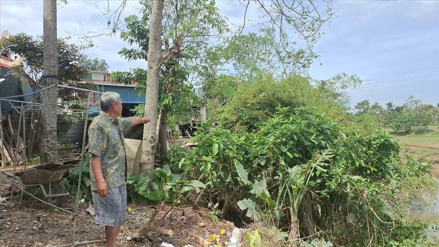 Nước sông đã ăn sâu sát mé nhà bên trái của thương binh Nguyễn Đình Ngọ. (Ảnh Phạm Tiến)