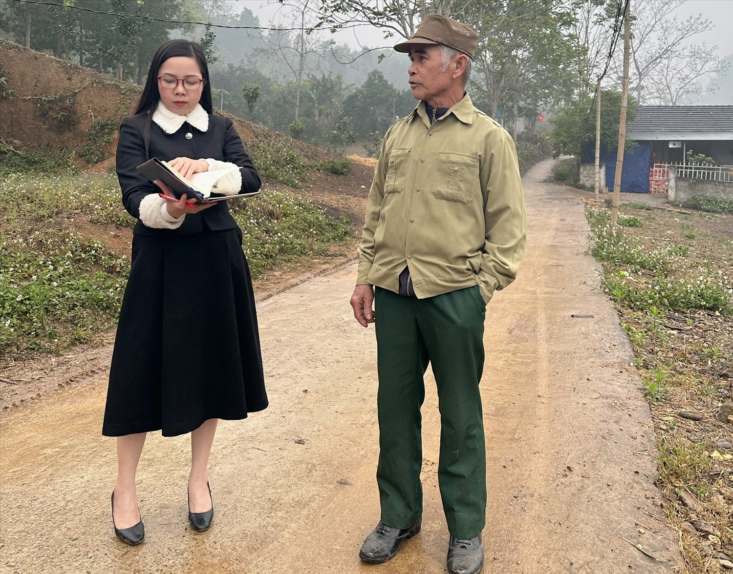 Cựu chiến binh - Người có uy tín Đào Xuân Lư chia sẻ với tác giả trên tuyến đường bỏ tiền ra đổ đất, san đường cho trẻ nhỏ trong thôn đi học trước khi được bê tông hoá.
