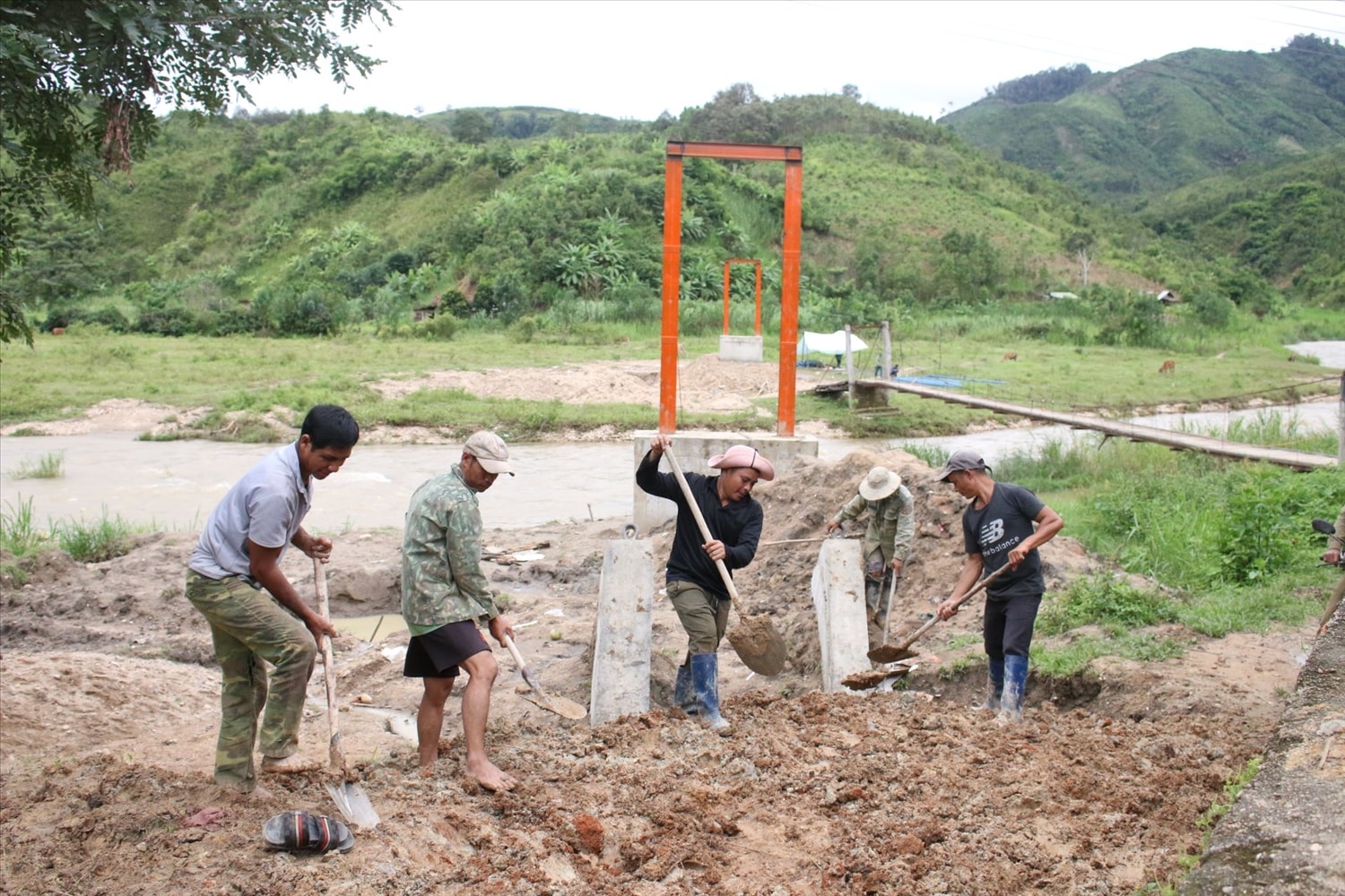 Nhân dân thôn Pêng Sal Pêng, xã Đăk Pék chung tay, góp sức cùng với các đơn vị xây dựng sớm hoàn thành cây cầu treo dân sinh bắt qua suối Đăk Mỹ. (Ảnh: Ngọc Chí)