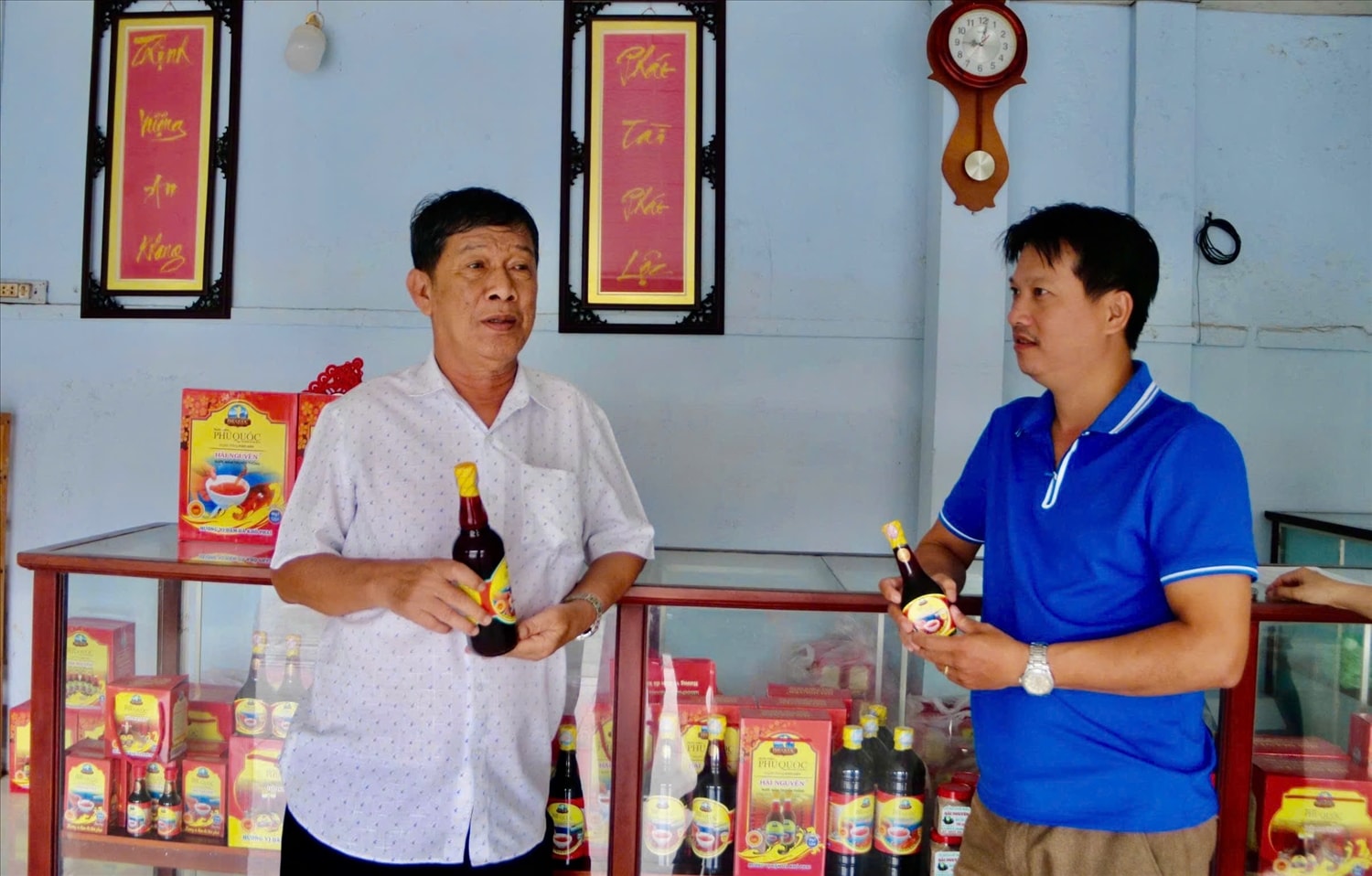 Ông Danh Phúc bên sản phẩm nước mắm do chính ông nghiên cứu và sản xuất