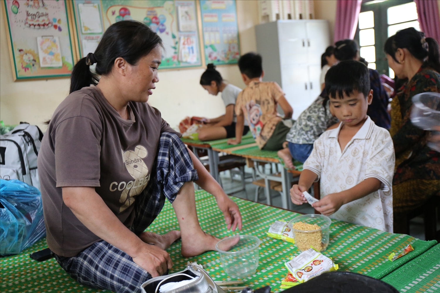 Chị Nguyễn Thị Biên ở xóm Hải Bắc tâm sự: Lên đây rồi thì không còn lo gì nữa, được bố trí nơi ăn, ở chu đáo. Giờ chỉ lo tài sản, nhà cửa ở nhà thôi - Ảnh: Thanh Hải