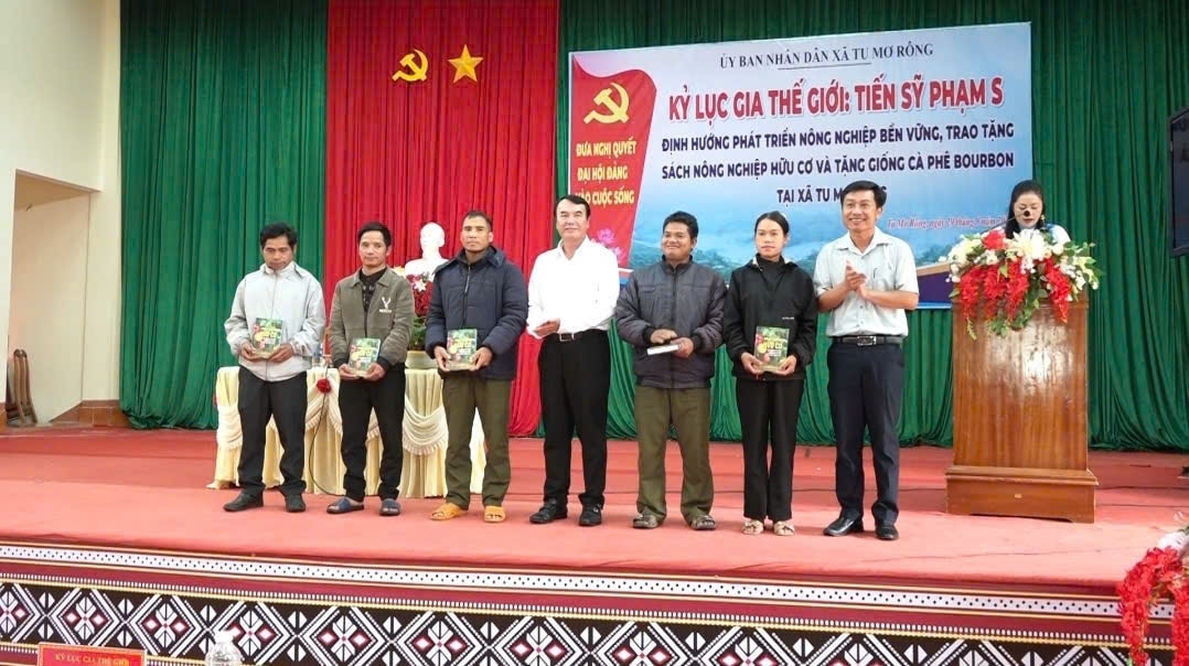 Tiến sĩ Phạm S (đứng giữa) tặng sách “Nông nghiệp hữu cơ, xu hướng tất yếu tham gia chuỗi nông sản toàn cầu” cho đồng bào Xơ Đăng xã Tu Mơ Rông. (Ảnh: Ngọc Chí)
