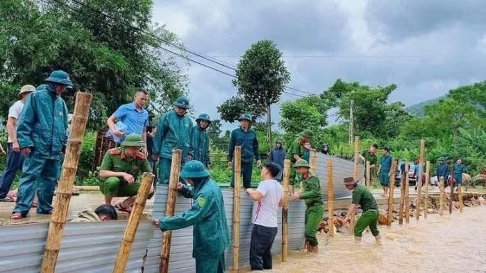 Công an xã Hùng Chân, tỉnh Nghệ An phối hợp chính quyền địa phương và nhân dân khắc phục tuyến đường qua bản Luông bị xói lở do mưa bão gây ra. (Ảnh ĐÌNH PHƯỢNG)