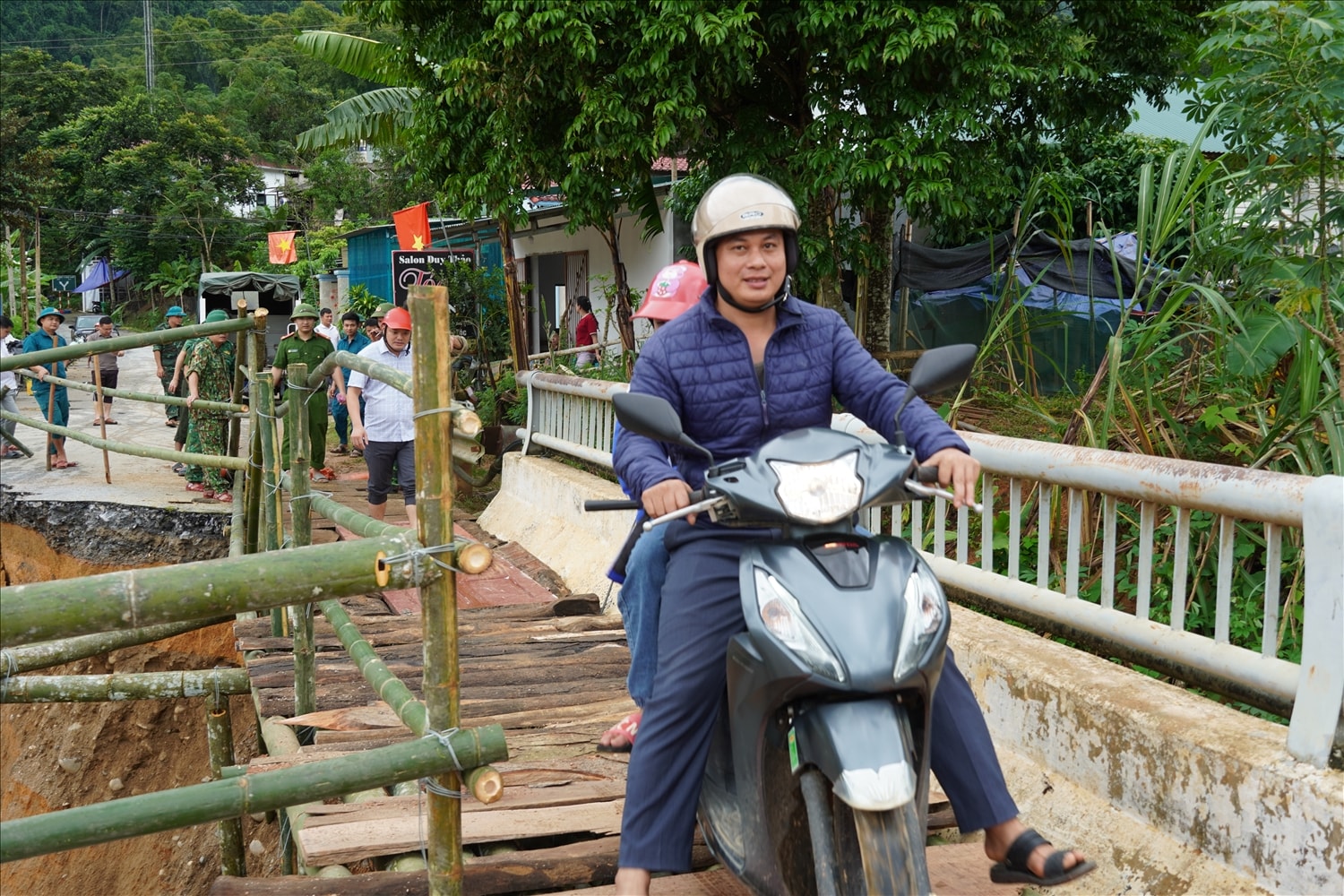 Bà con nhân dân 2 bên đầu cầu vui mừng khi được đi lại thuận tiện trên cây cầu tạm