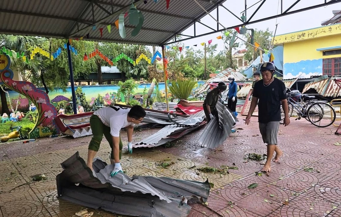 Lực lượng chức năng hỗ trợ nhà trường dọn dẹp vệ sinh sau bão.