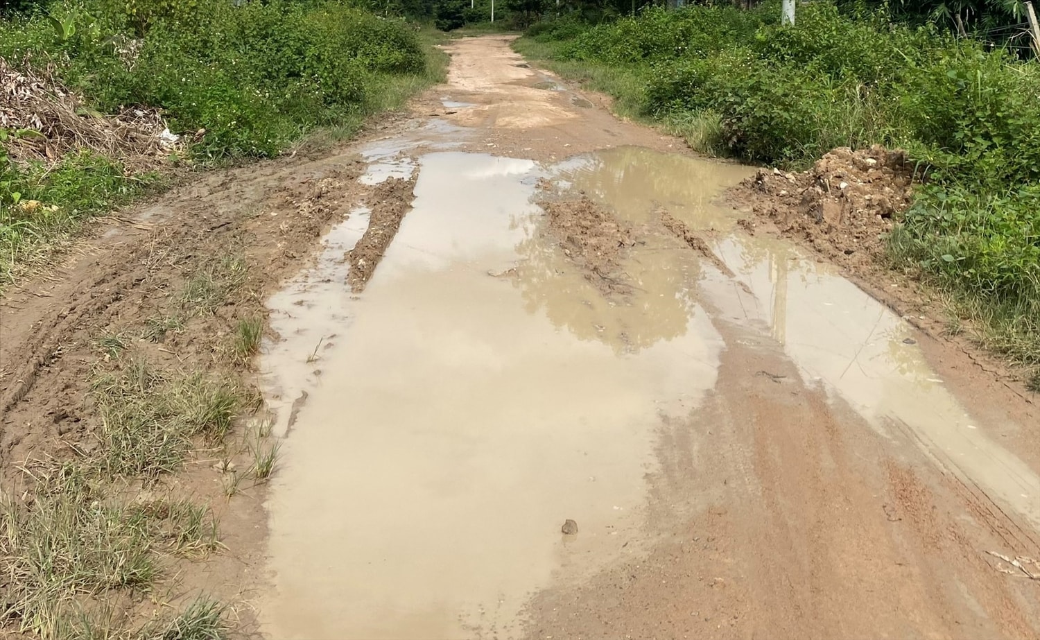 Do không được đầu tư xây dựng, vào mùa mưa, người dân phải đi lại trên con đường bùn đất. (Ảnh: Ngọc Chí)