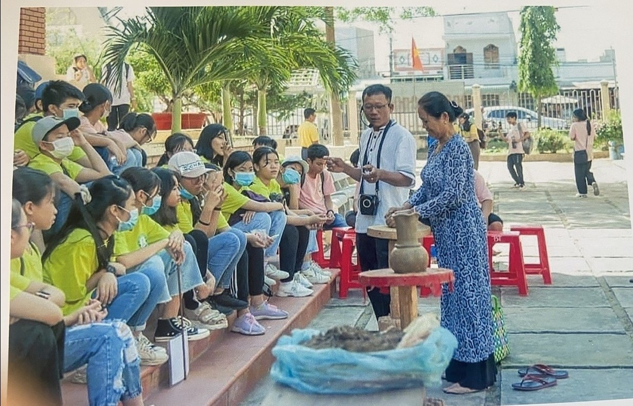 Học sinh Trường THCS Hàm Tân xem nghệ nhân Lương Thị Hòa trình diễn gốm mỹ nghệ trong chương trình trải nghiệm ngoại khóa tại Trung tâm Trưng bày Văn hóa Chăm Bình Thuận.