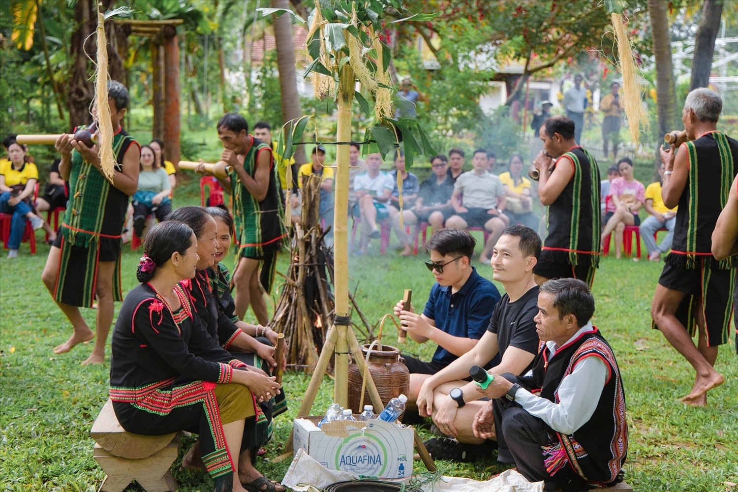 Du khách cùng bà con quây quần quanh ché rượu cần, thưởng thức hương vị mộc mạc của núi rừng