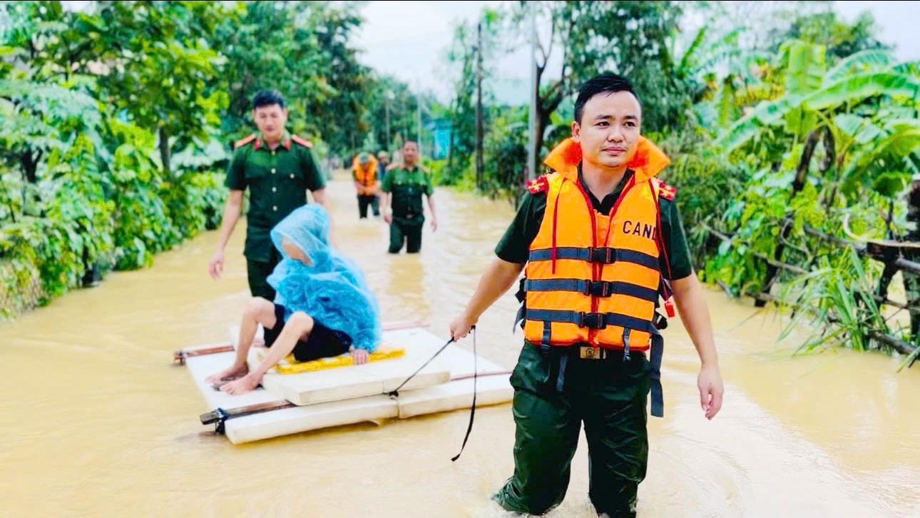 Hình ảnh cán bộ, chiến sĩ Công an xã Vân Du dầm mình trong nước lũ đưa cụ bà Nguyễn Thị Ký đến nơi an toàn