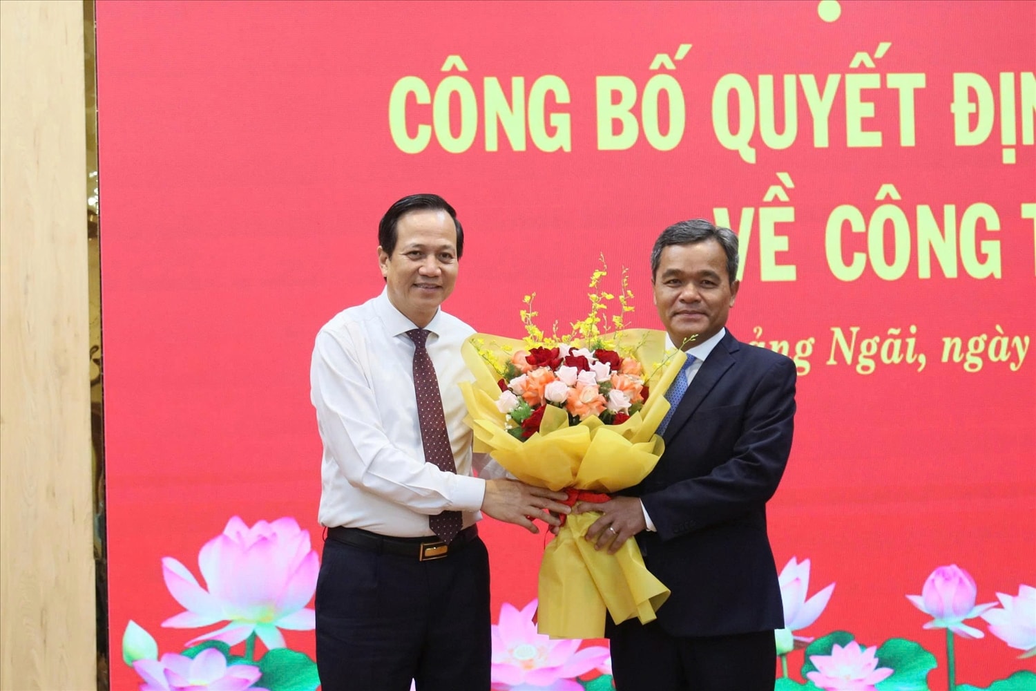 Bộ trưởng Bộ Dân tộc và Tôn giáo Đào Ngọc Dung (trái) tặng hoa chúc mừng ông Hồ Văn Niên. (Ảnh Nhân Nhân).