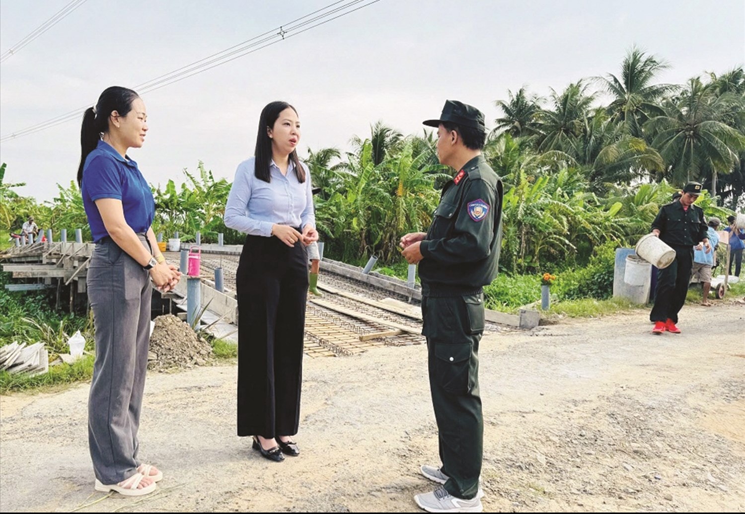 Lãnh đạo Ủy ban MTTQ xã Song Lộc, tỉnh Vĩnh Long trao đổi với lực lượng Công an trong hỗ trợ xây dựng cầu giao thông nông thôn, góp phần thực hiện mô hình chính quyền địa phương 2 cấp.  Ảnh: TL