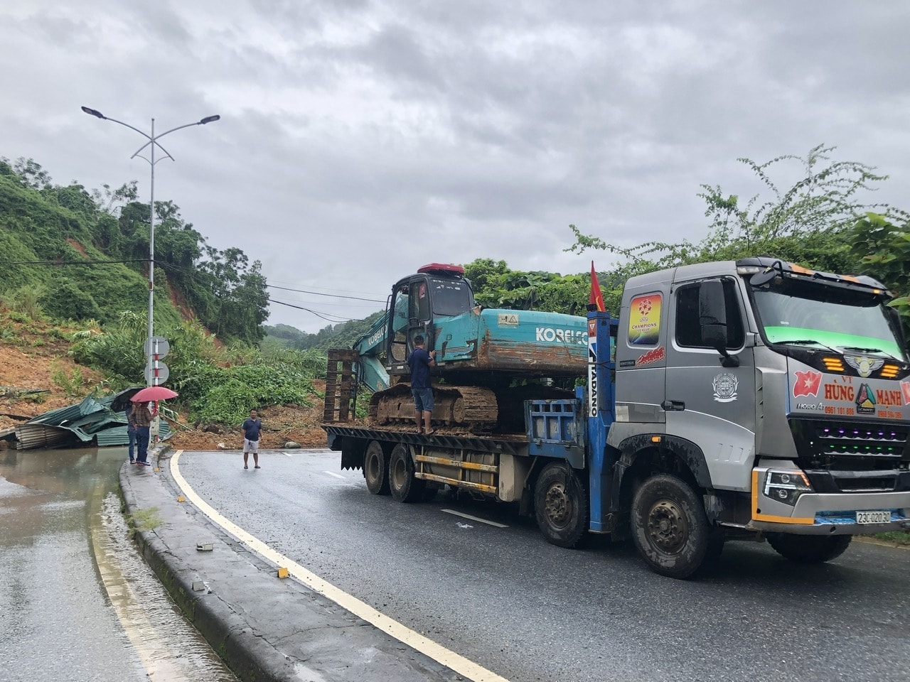 Huy động phương tiện, máy móc để giải phóng đất đá bị sụt sạt (ảnh Trọng Bảo)