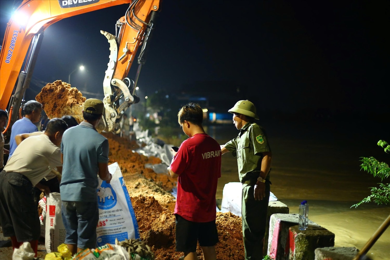 Huy động tối đa nhân vật lực và các lực lượng cùng người dân gia cố đe Chã ngay trong đêm. (Ảnh: Quang Duy)