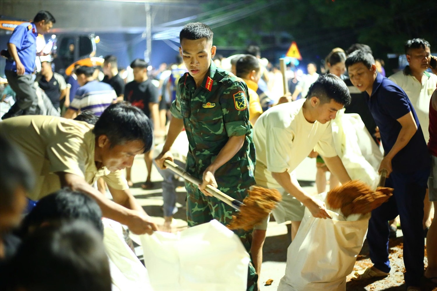 Sư đoàn 312 (Quân đoàn 12) đã huy động hàng trăm cán bộ, chiến sĩ cùng phương tiện cơ giới, cuốc xẻng, bao tải cát… để gia cố tuyến đê với tổng chiều dài khoảng 500m.  (Ảnh: Quang Duy)