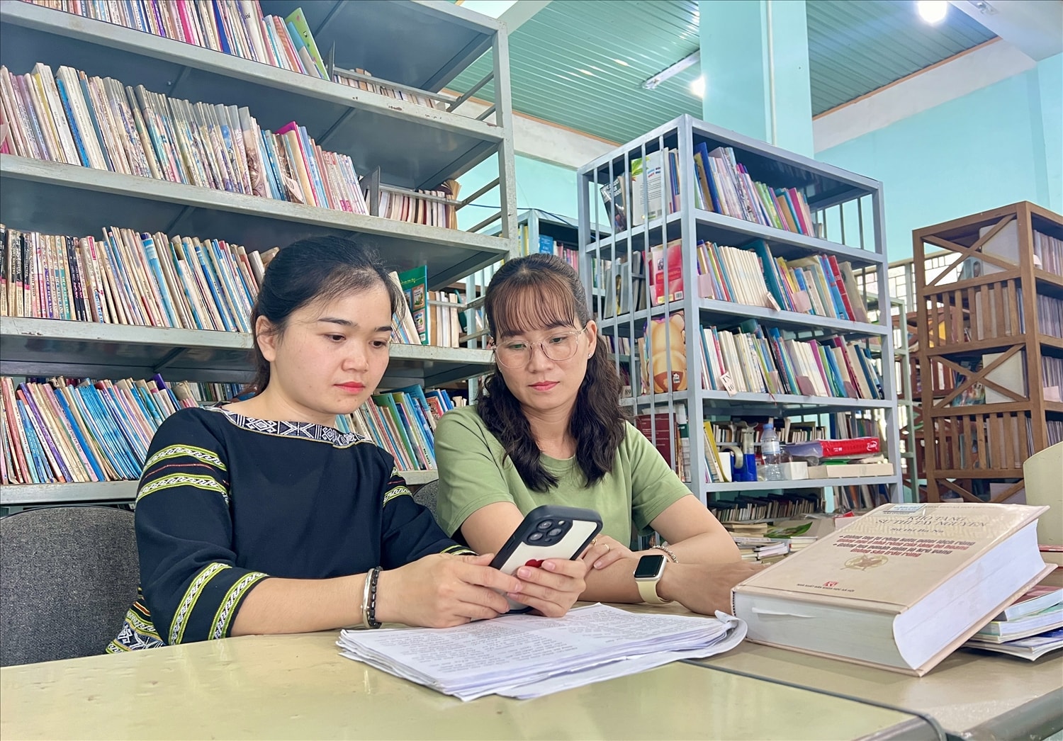 Chị Aya (bên trái ảnh) đang cùng bạn chia sẻ ứng dụng từ điển số tiếng Kinh - Ba Na