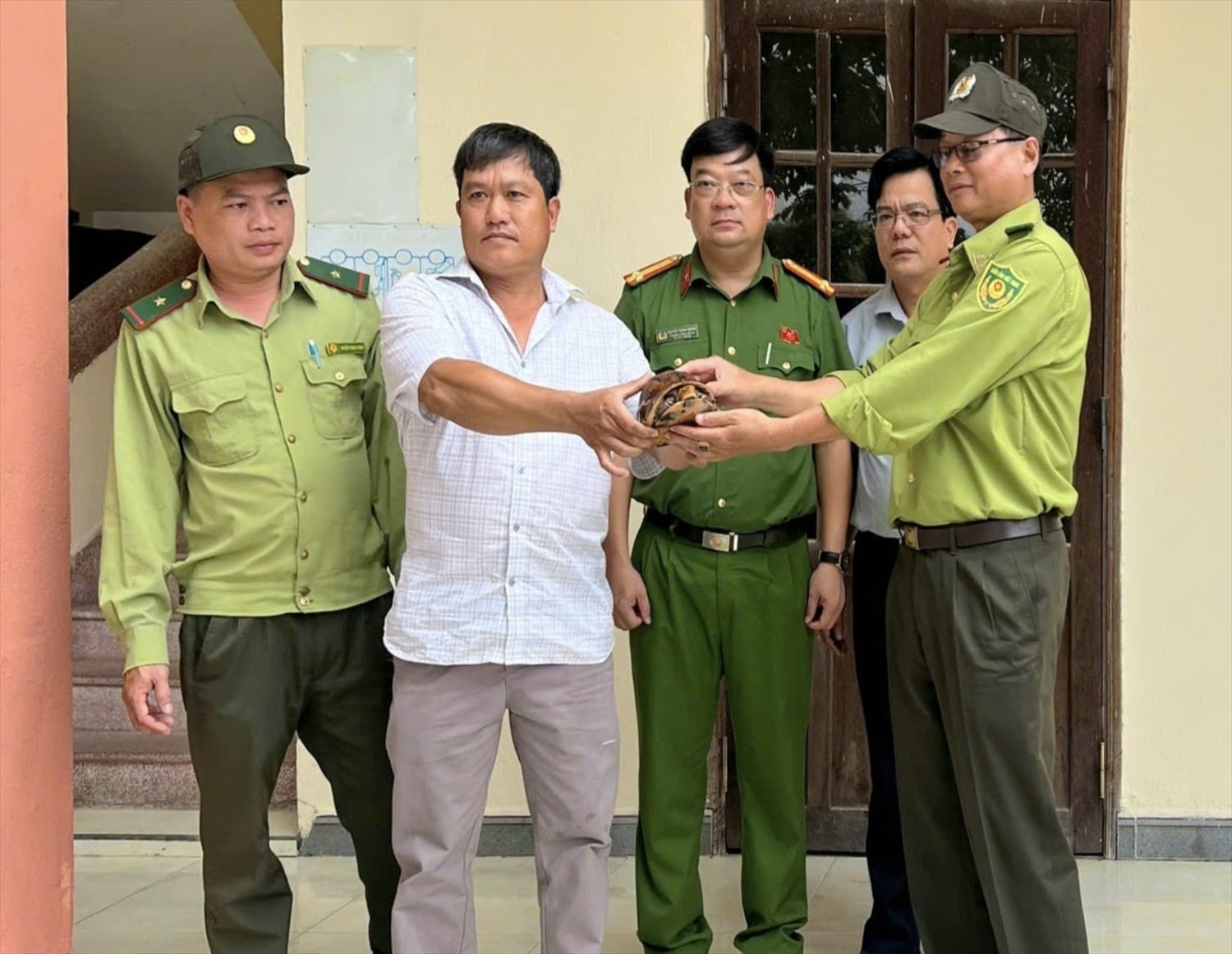 Anh Hoà bàn giao rùa quý cho lực lượng chức năng. (Ảnh Công an cung cấp).