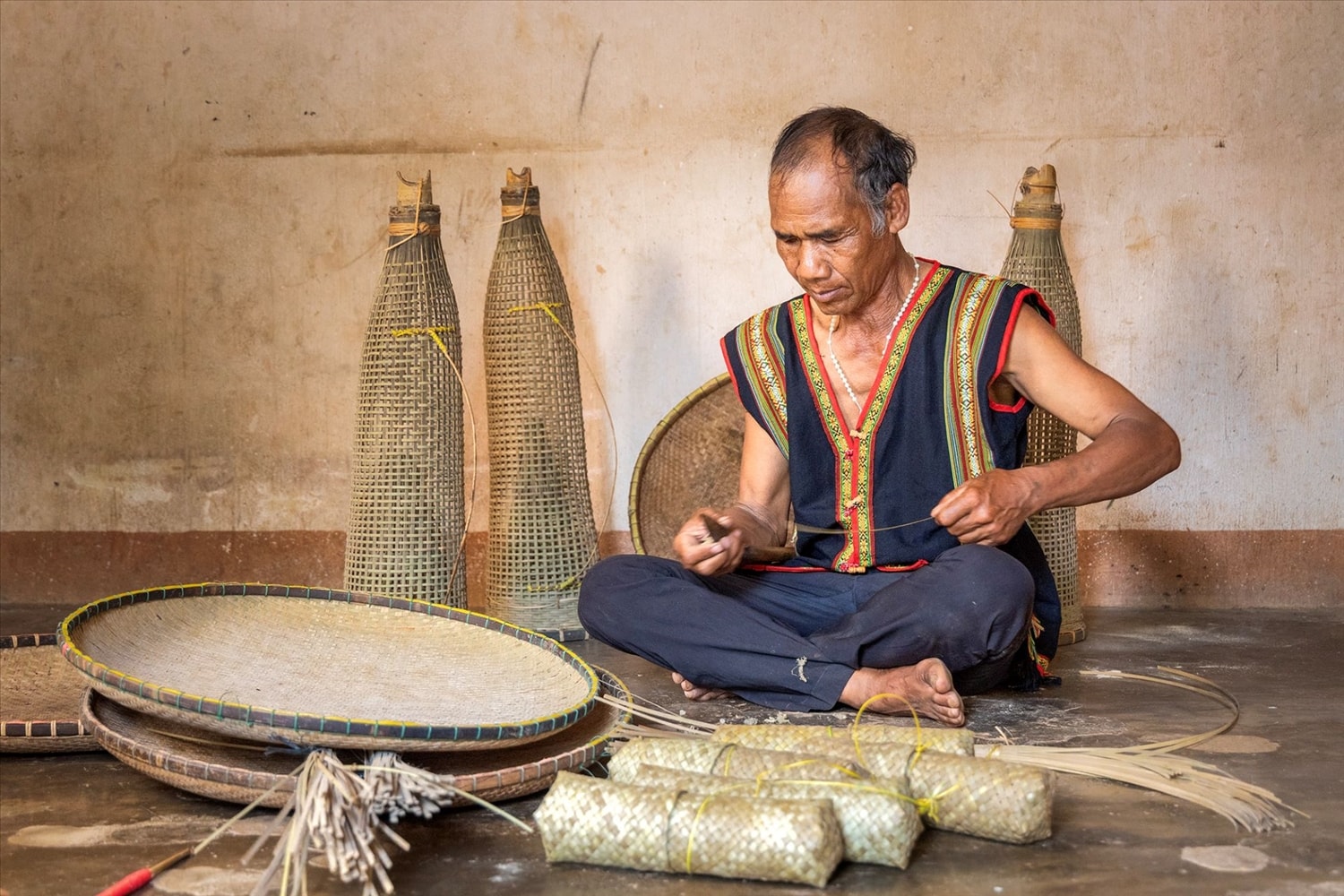 Nghệ nhân A Tút vẫn miệt mài giữ nghề đan lát truyền thống của người Xơ Đăng. (Ảnh: Ngọc Chí) 