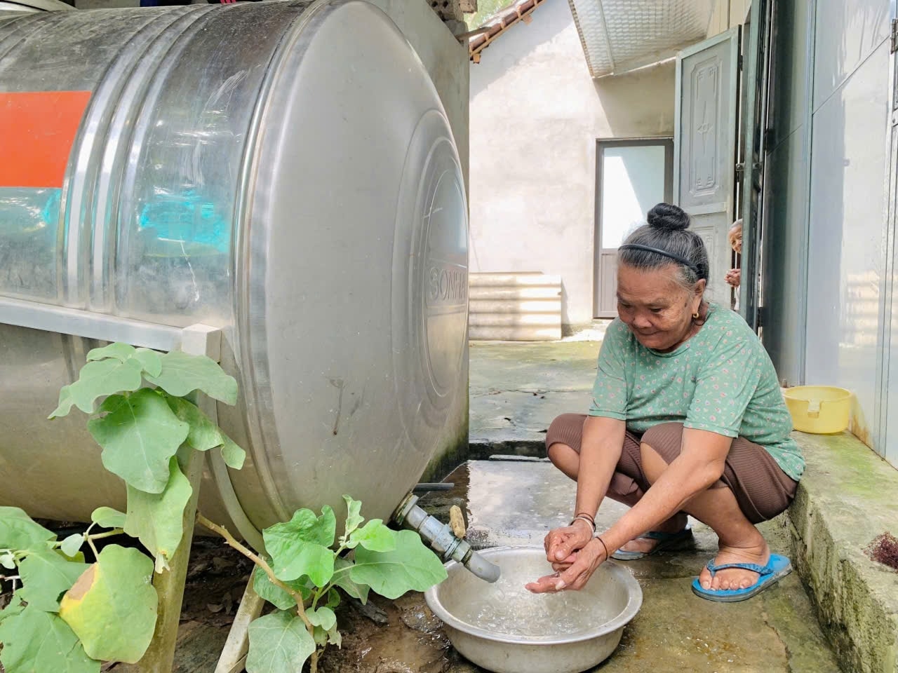 Bà Lương Thị Lợi, bản Na Bón, xã Yên Na phấn khởi sử dụng nguồn nước đảm bảo vệ sinh tại nhà. Bà chia sẻ : Gia đình đã thoát khỏi cảnh phải đi xuống suối lấy nước về dùng