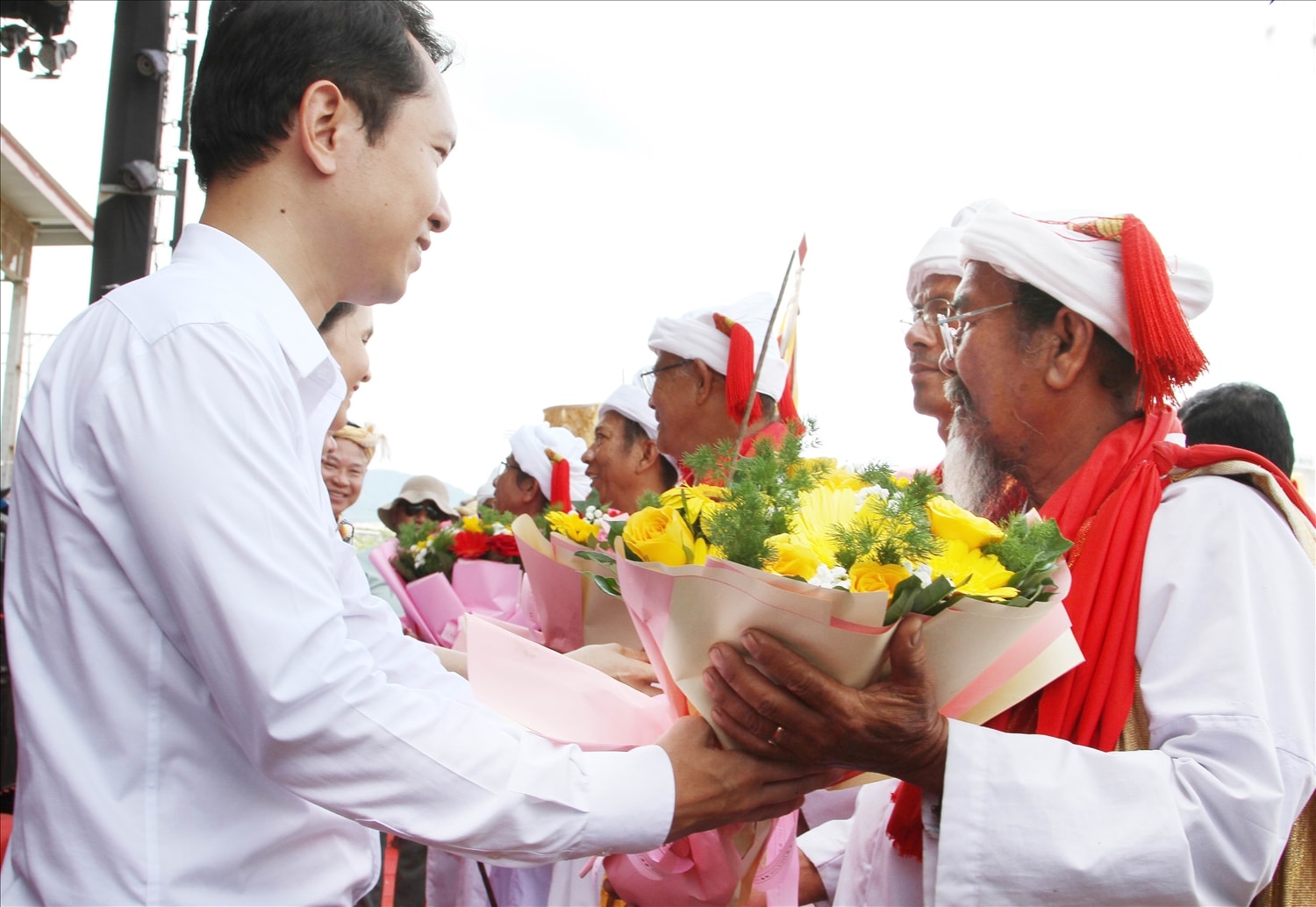 Ông Nguyễn Đức Nghĩa, Chủ tịch UBND xã Phước Hữu, tặng hoa chúc mừng các vị chức sắc làng Hữu Đức tại Lễ rước y trang Nữ thần Pô Inư Nưgar.