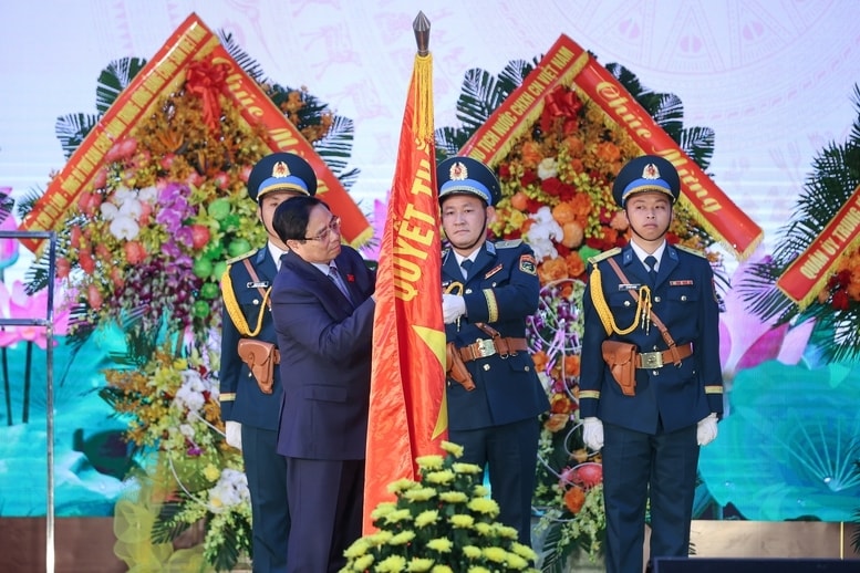 Thủ tướng Phạm Minh Chính gắn huy hiệu Danh hiệu Anh hùng lực lượng vũ trang nhân dân lên Quân kỳ Quyết thắng của Quân chủng Phòng không - Không quân - Ảnh: VGP/Nhật Bắc