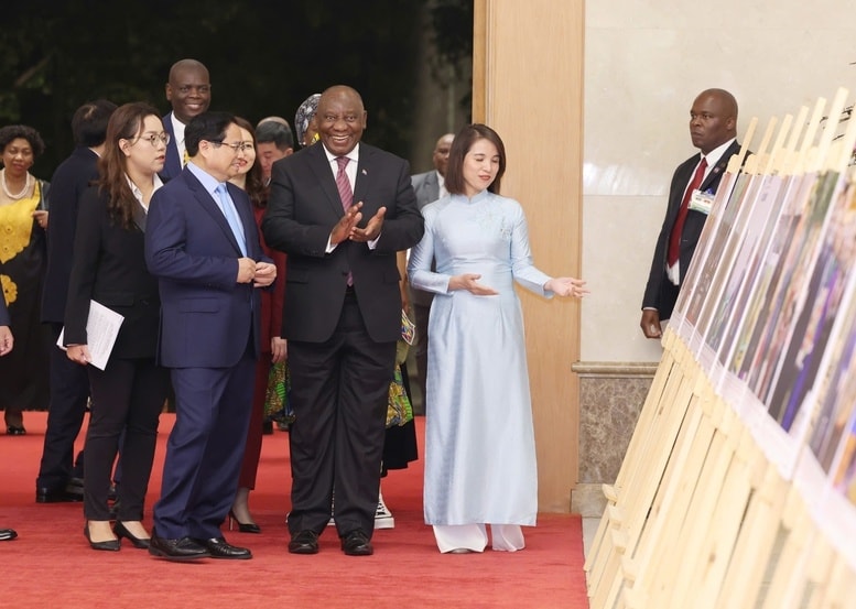 Thủ tướng Phạm Minh Chính và Tổng thống Cyril Ramaphosa tham quan trưng bày ảnh về quan hệ hợp tác Việt Nam - Nam Phi - Ảnh: VGP/Nhật Bắc