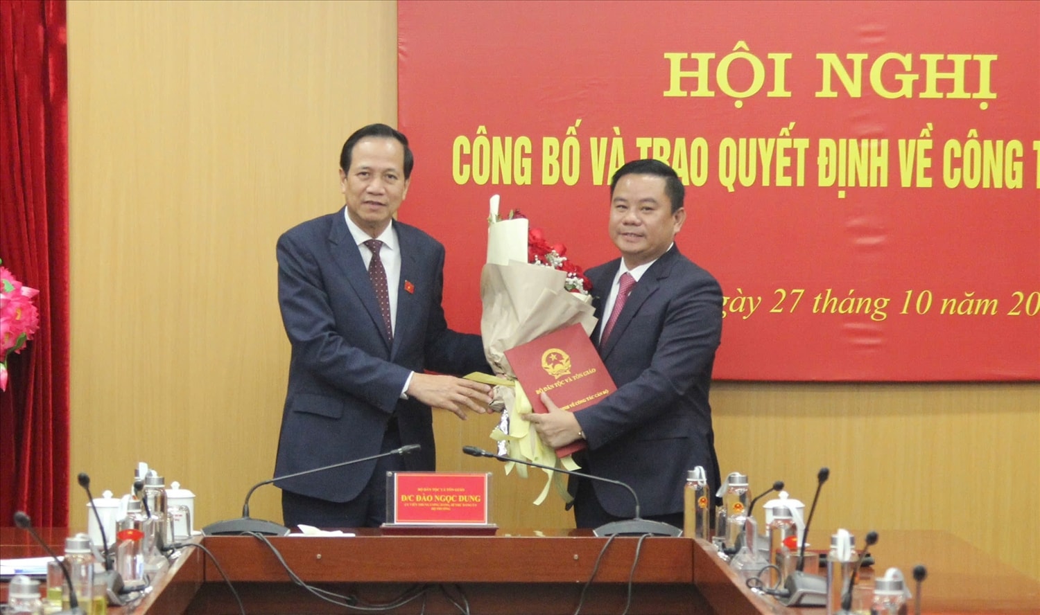 Bí thư Đảng ủy, Bộ trưởng Bộ Dân tộc và Tôn giáo Đào Ngọc Dung trao Quyết định điều động, bổ nhiệm và tặng hoa chúc mừng tân Chánh Văn phòng Đảng ủy Đào Xuân Quy. Ảnh: Hoàng Quý