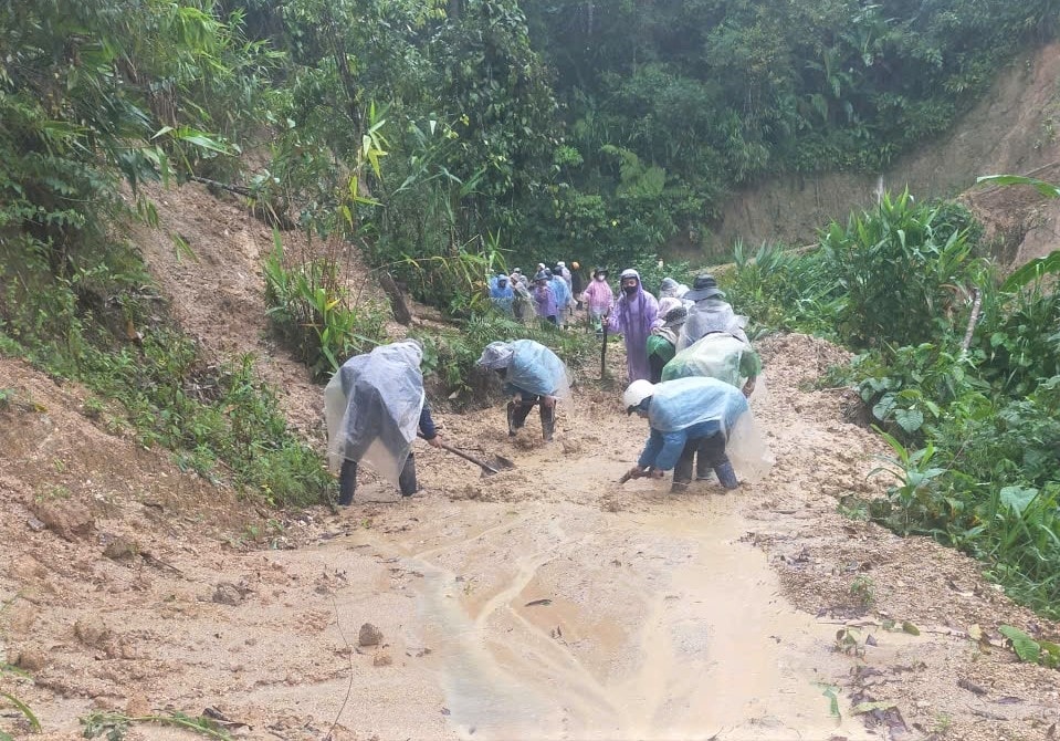Người dân thôn Đăk Nai, xã Ngọc Linh tập trung khắc phục sạt lở trên tuyến đường dẫn lên thôn. (Ảnh: Ngọc Chí)