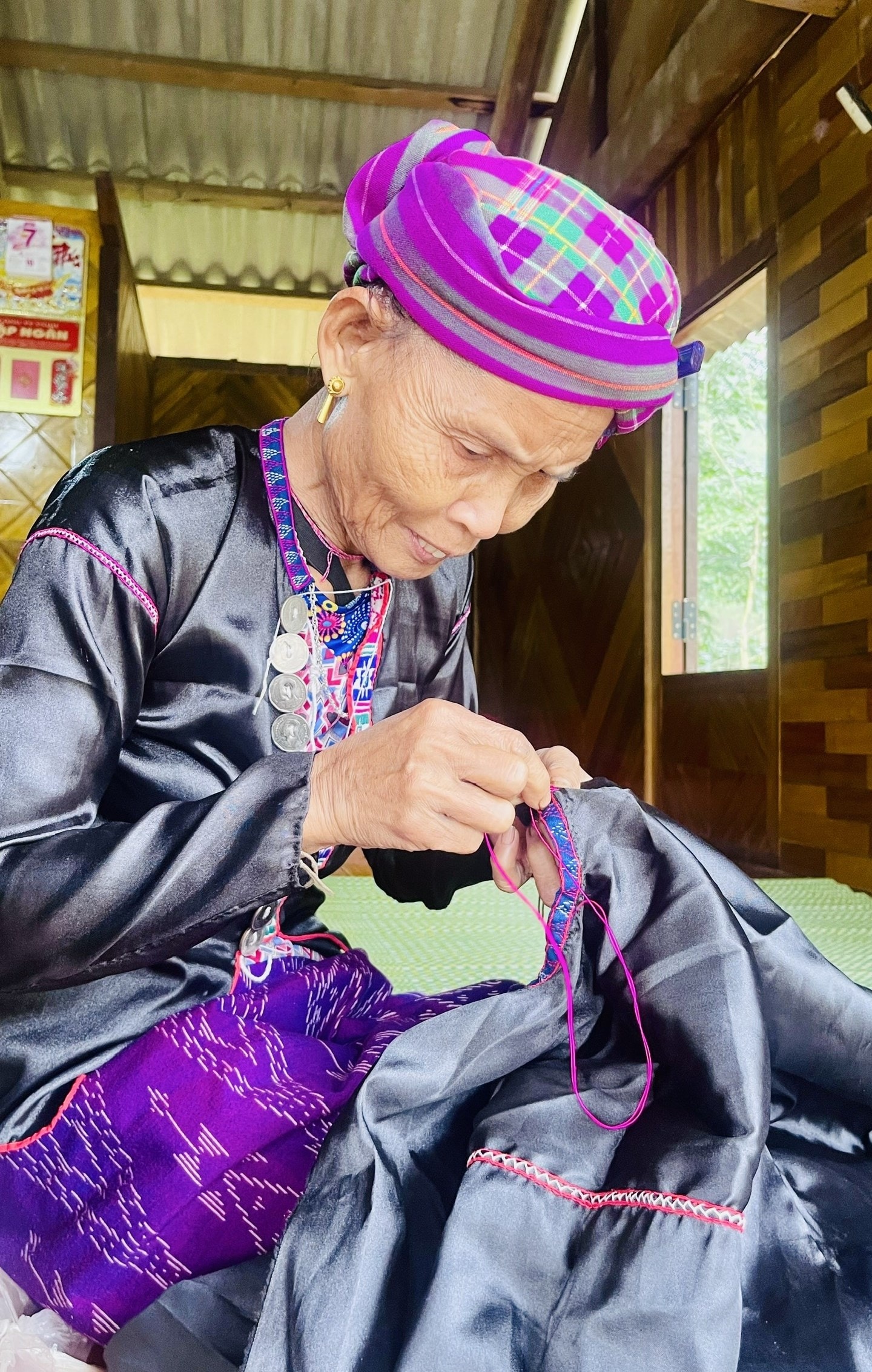 Bà Hồ Thị Loi tỉ mỉ từng đường kim múi chỉ khi may áo truyền thống