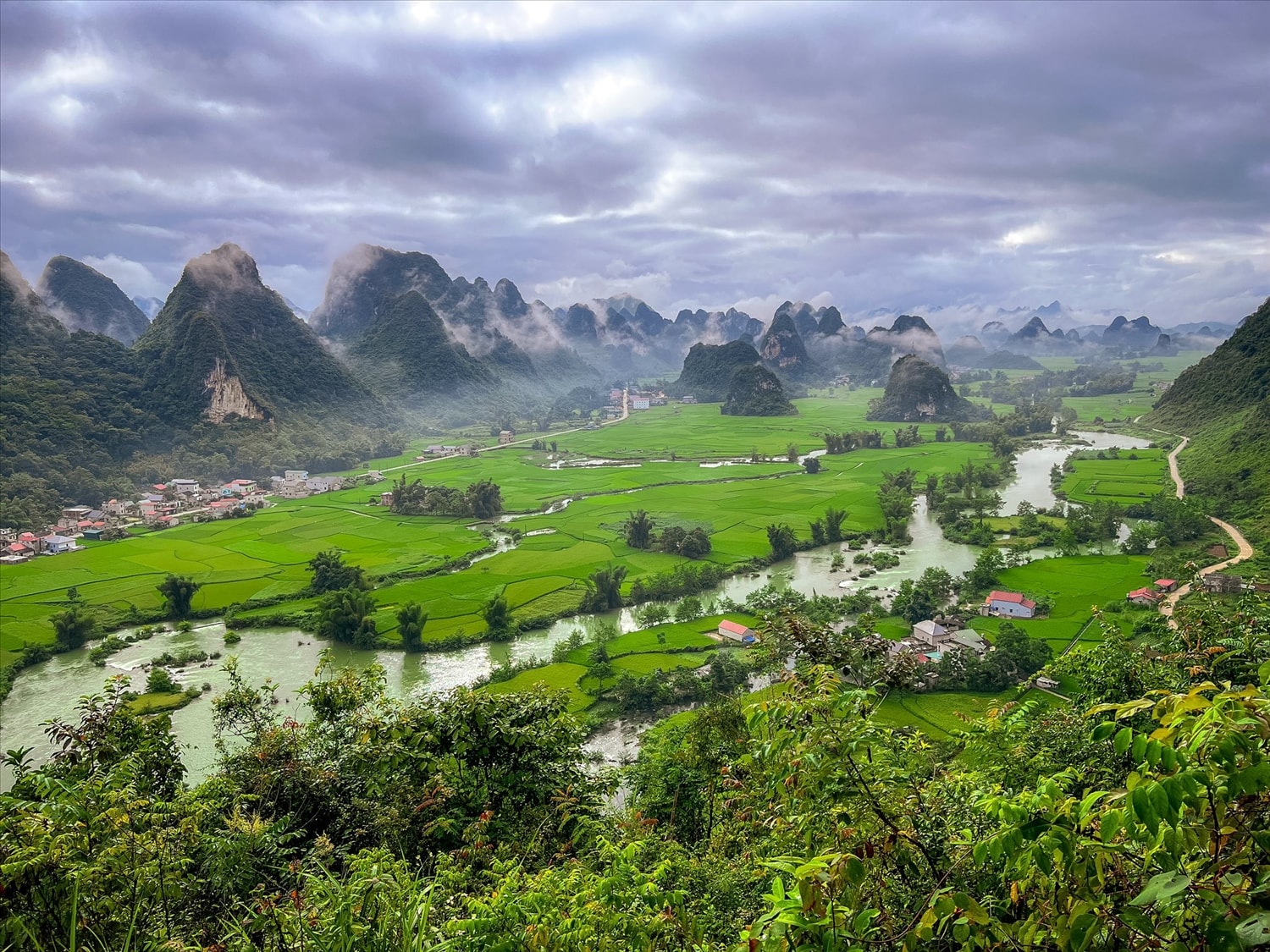 Dòng sông uốn lượn mềm mại, dẫn lối qua ruộng đồng và những nếp nhà yên bình.