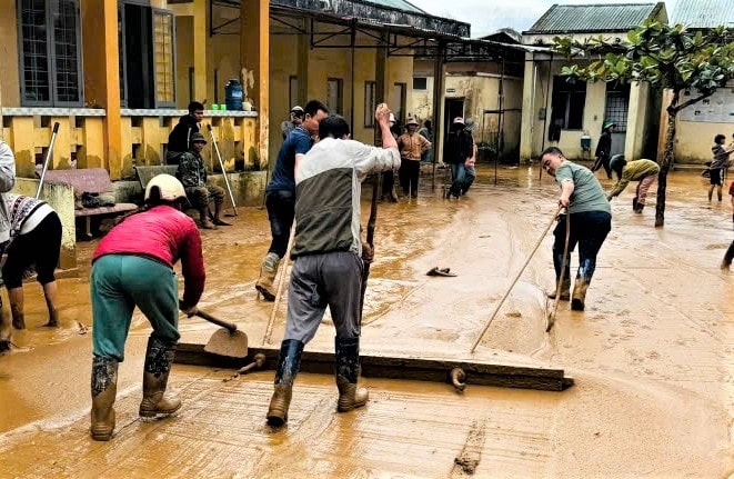 Những lớp bùn đất dày được san gạt ra khỏi sân trường. (Ảnh: Ngọc Chí)